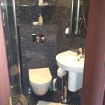 Łazienka z granitu z wc, prysznicem i umywalką